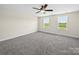Spacious bedroom features plush carpeting, a ceiling fan, and natural light from two windows at 3012 Isle Ln, Monroe, NC 28110