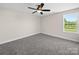 Empty bedroom with plush carpeting, a ceiling fan, and a bright window at 3012 Isle Ln, Monroe, NC 28110