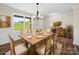 A dining room featuring a wooden table, seating for six, a window and sideboard at 3012 Isle Ln, Monroe, NC 28110