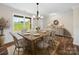 Cozy dining room with wood floors, large window, chandelier, and seating for six at 3012 Isle Ln, Monroe, NC 28110