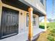 Welcoming entrance with stylish wooden columns, a black door, and manicured landscaping at 3012 Isle Ln, Monroe, NC 28110