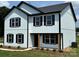 Charming two-story home featuring white siding, black trim, and a welcoming front porch at 3012 Isle Ln, Monroe, NC 28110
