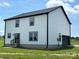 Back exterior featuring white siding, black trim, with garage, and slider leading to small deck at 3012 Isle Ln, Monroe, NC 28110