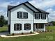 Beautiful two-story home with white siding, black trim, complemented by professionally landscaped yard at 3012 Isle Ln, Monroe, NC 28110