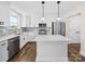 Open-concept kitchen with a large island, white cabinetry, stainless appliances, and modern finishes at 3012 Isle Ln, Monroe, NC 28110
