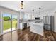 This spacious kitchen features stainless appliances, an island, and sliding glass doors leading to the yard at 3012 Isle Ln, Monroe, NC 28110