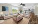 A brightly lit living room featuring neutral furniture, ceiling fan and views to the kitchen and the yard at 3012 Isle Ln, Monroe, NC 28110