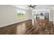 Open-concept living space features hardwood floors, a ceiling fan, and a bright window with views of the outdoors at 3012 Isle Ln, Monroe, NC 28110
