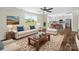 A brightly lit living room featuring neutral furniture, ceiling fan and views to the kitchen and the yard at 3012 Isle Ln, Monroe, NC 28110