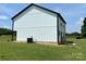Side exterior featuring white siding, black trim, and slider leading to small deck at 3012 Isle Ln, Monroe, NC 28110