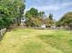Spacious backyard with lush green grass and a charming wooden fence, providing privacy at 3017 Planters Walk Ct, Charlotte, NC 28210
