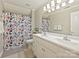 Bright bathroom with double vanity, framed mirror, and floral shower curtain that accents the space at 3017 Planters Walk Ct, Charlotte, NC 28210