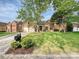 Charming brick home with a well-manicured front lawn, mature trees, and a welcoming driveway at 3017 Planters Walk Ct, Charlotte, NC 28210