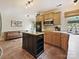 Kitchen featuring a functional center island, light wood cabinets, and a seamless flow to the living area at 3017 Planters Walk Ct, Charlotte, NC 28210