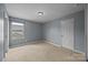 Cozy bedroom with a neutral carpet, a light fixture, and a view of the surrounding neighborhood at 303 Landis Oak Way, Landis, NC 28088