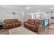 Open living room with ceiling fan, wood floors, and comfortable leather furniture at 320 Silver Oak Cir, Rockwell, NC 28138