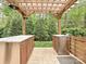 Outdoor kitchen with granite countertops, stainless steel appliances, and wooden pergola with lighting at 358 Hampton Trail Dr, Fort Mill, SC 29708