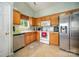 Cozy kitchen featuring stainless steel appliances, ample wood cabinetry, and neutral tile floors at 3606 White Swan Ct, Indian Trail, NC 28079