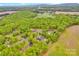 Overhead shot displays homes nestled in a verdant, tree-filled neighborhood near large green fields at 3871 Cool Branch Dr, Maiden, NC 28650