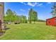 Expansive backyard featuring a deck, outdoor seating, and a charming red barn-style outbuilding at 3871 Cool Branch Dr, Maiden, NC 28650