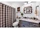 Bright bathroom featuring modern fixtures, granite countertop, decorative mirror, and a plaid shower curtain at 3871 Cool Branch Dr, Maiden, NC 28650