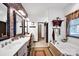 Bright bathroom featuring double vanity, brick accent wall, soaking tub, and lots of natural light at 3871 Cool Branch Dr, Maiden, NC 28650