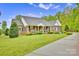 Stately brick home with a welcoming front porch, lush lawn, and manicured landscaping at 3871 Cool Branch Dr, Maiden, NC 28650
