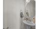 Well-lit powder room featuring a pedestal sink, round mirror, and modern fixtures at 4100 Alexander View Dr # 1, Charlotte, NC 28226
