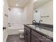 Contemporary bathroom with granite countertop, gray cabinets, and a tub with shower at 4149 River Run Cir, Hickory, NC 28602