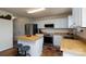 Eat-in kitchen featuring white cabinets, stainless steel appliances, a wood counter, and two stools at 4315 Barnside Ln, Charlotte, NC 28216