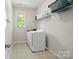 Bright laundry room featuring a washer, dryer, and shelving for storage near a window at 513 Sandbar Pt, Lake Wylie, SC 29710