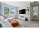 Bright living room with large windows, a comfortable couch, and modern entertainment center at 513 Sandbar Pt, Lake Wylie, SC 29710