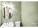 Cozy half bathroom featuring a modern sink, toilet, and a well-lit mirror at 6728 Mimosa St, Indian Trail, NC 28079