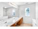 Bathroom with double vanity, expansive mirror, window, and combined tub and shower at 6728 Mimosa St, Indian Trail, NC 28079