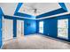 Large bedroom features blue walls, natural light, tray ceiling, and ceiling fan at 6728 Mimosa St, Indian Trail, NC 28079