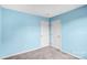 A simple bedroom with light blue walls, carpeted floor, and a double closet at 6728 Mimosa St, Indian Trail, NC 28079