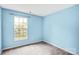 Bedroom featuring blue walls, grey carpeting, and large window providing natural light at 6728 Mimosa St, Indian Trail, NC 28079