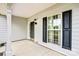 Covered front porch with stylish door and window, complemented by dark shutters at 6728 Mimosa St, Indian Trail, NC 28079