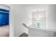 Bright hallway featuring stairs with natural light through a window and modern chandelier at 6728 Mimosa St, Indian Trail, NC 28079