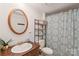 Clean bathroom with a shower-tub combo, patterned shower curtain, and ample storage space at 6778 Emerald Isle Dr, Sherrills Ford, NC 28673