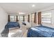 Bright bedroom with two beds, multiple windows, and a ceiling fan at 6778 Emerald Isle Dr, Sherrills Ford, NC 28673
