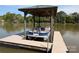 Covered boat dock features a blue pontoon on a sunny lake with treelined backdrop at 6778 Emerald Isle Dr, Sherrills Ford, NC 28673
