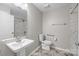 Bright bathroom featuring a pedestal sink and a shower with marble-style tile at 7502 Hurstbourne Green Dr, Charlotte, NC 28277