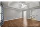 Spacious bedroom featuring hardwood floors, a ceiling fan, and an ensuite bathroom at 7502 Hurstbourne Green Dr, Charlotte, NC 28277
