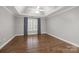 Bright bedroom with hardwood floors, ceiling fan, and natural light from the large window at 7502 Hurstbourne Green Dr, Charlotte, NC 28277