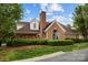 Attractive brick home showcasing lush landscaping, a tall chimney, and manicured lawn at 7502 Hurstbourne Green Dr, Charlotte, NC 28277