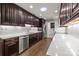 Spacious kitchen featuring stainless steel appliances, dark cabinets, and white countertops at 7502 Hurstbourne Green Dr, Charlotte, NC 28277