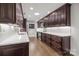 Well-lit kitchen with dark cabinets, stainless steel appliances, and light countertops at 7502 Hurstbourne Green Dr, Charlotte, NC 28277