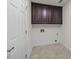 Laundry room features tiled flooring, hookups, and cabinetry for storage at 7502 Hurstbourne Green Dr, Charlotte, NC 28277