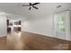 Spacious living room with fireplace, hardwood floors, natural light, and adjoined kitchen at 7502 Hurstbourne Green Dr, Charlotte, NC 28277